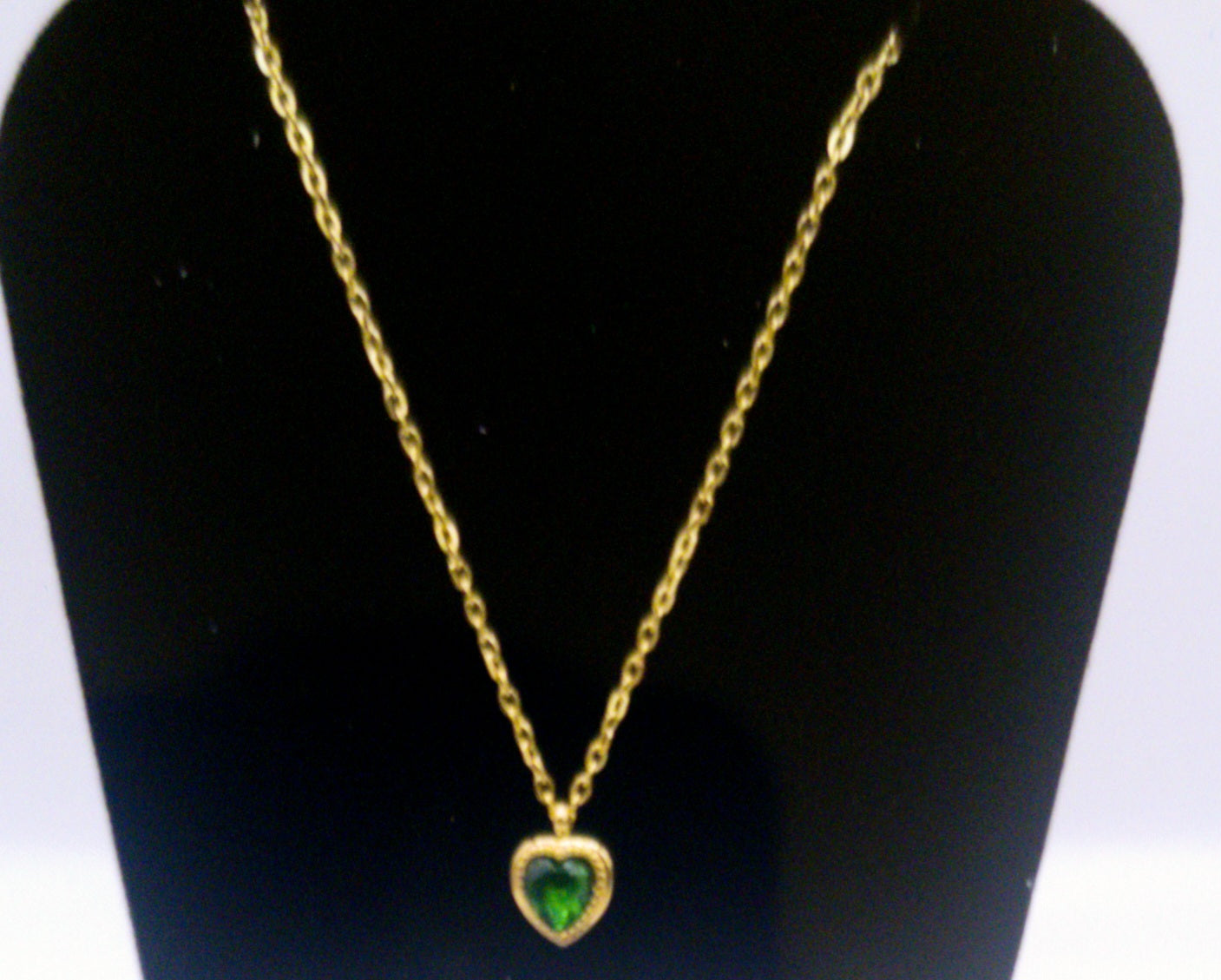 Chaînette en acier inoxydable avec médaille en forme de coeur vert.