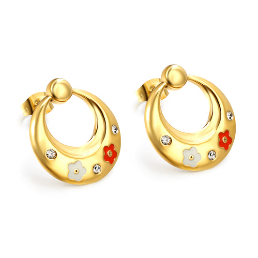 Boucles d’oreilles Créoles en acier inoxydable avec design de fleurs, ornées de petites pierres.